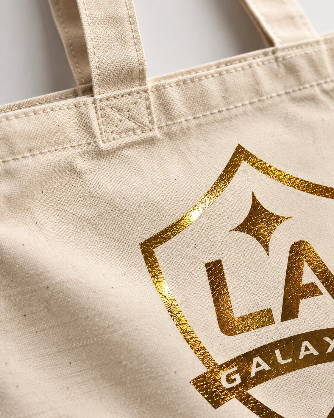 Gold foil crest detail with stitched tote handles