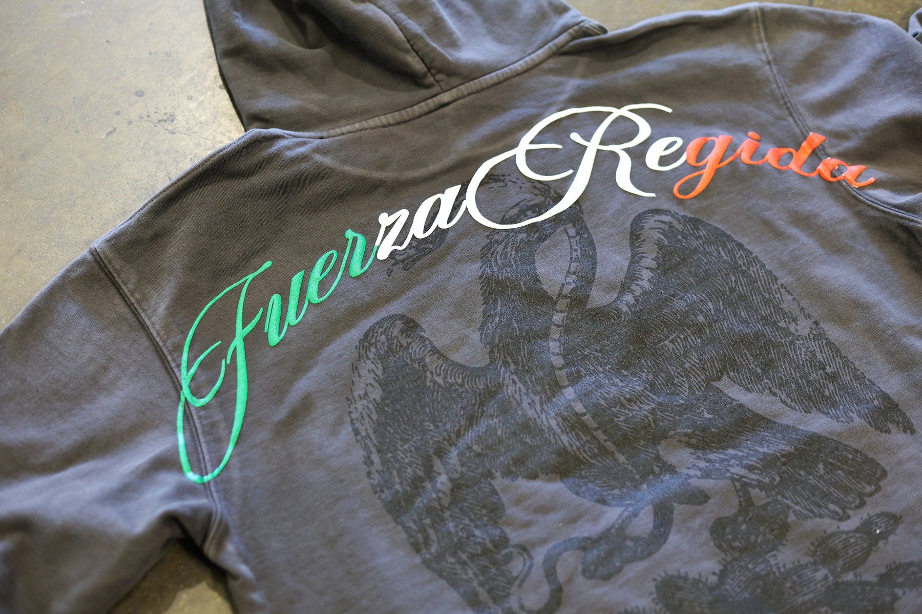 Gray hoodie with Fuerza Regida front print and tonal eagle artwork
