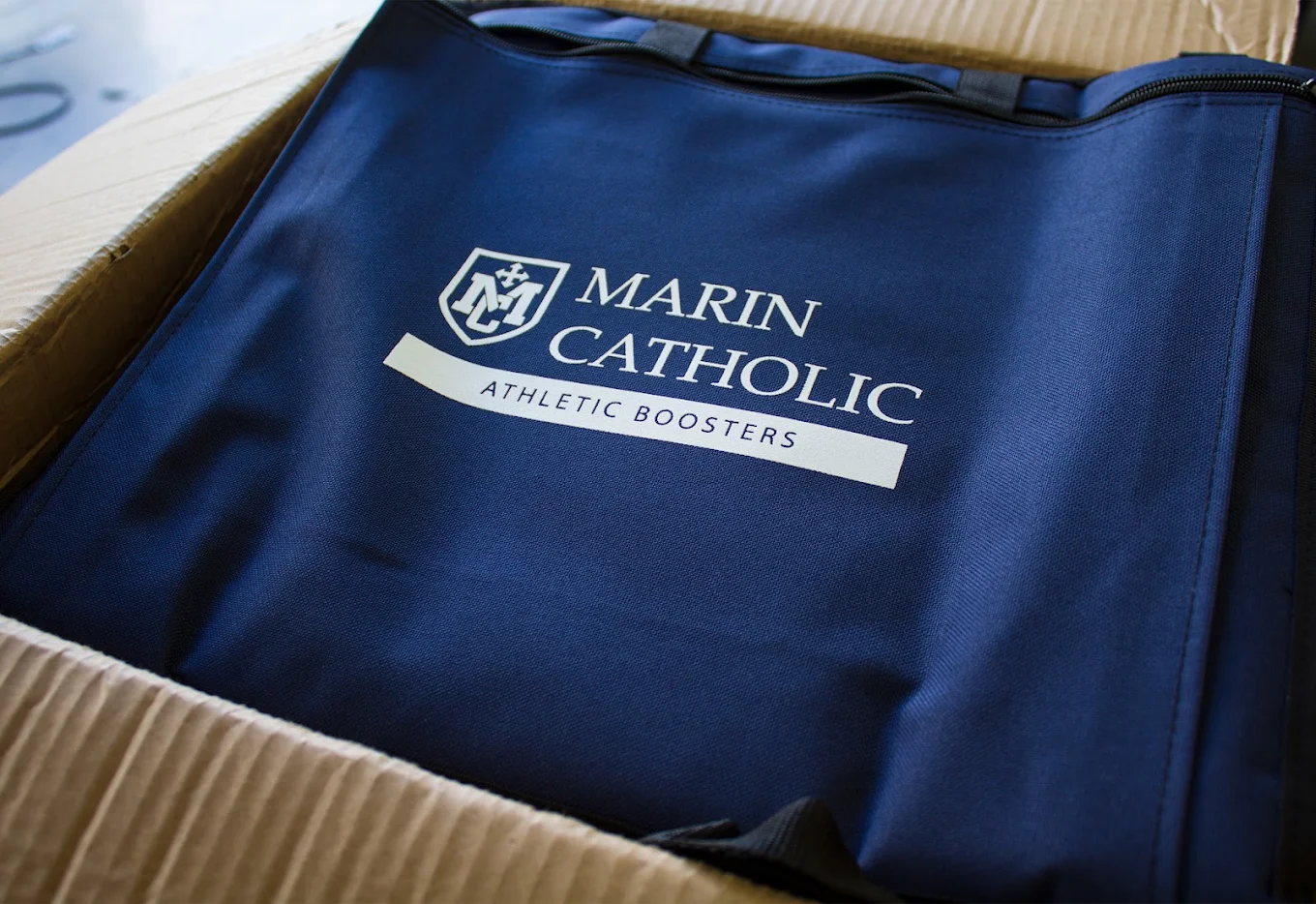 Blue athletic booster apparel stacked in a production box