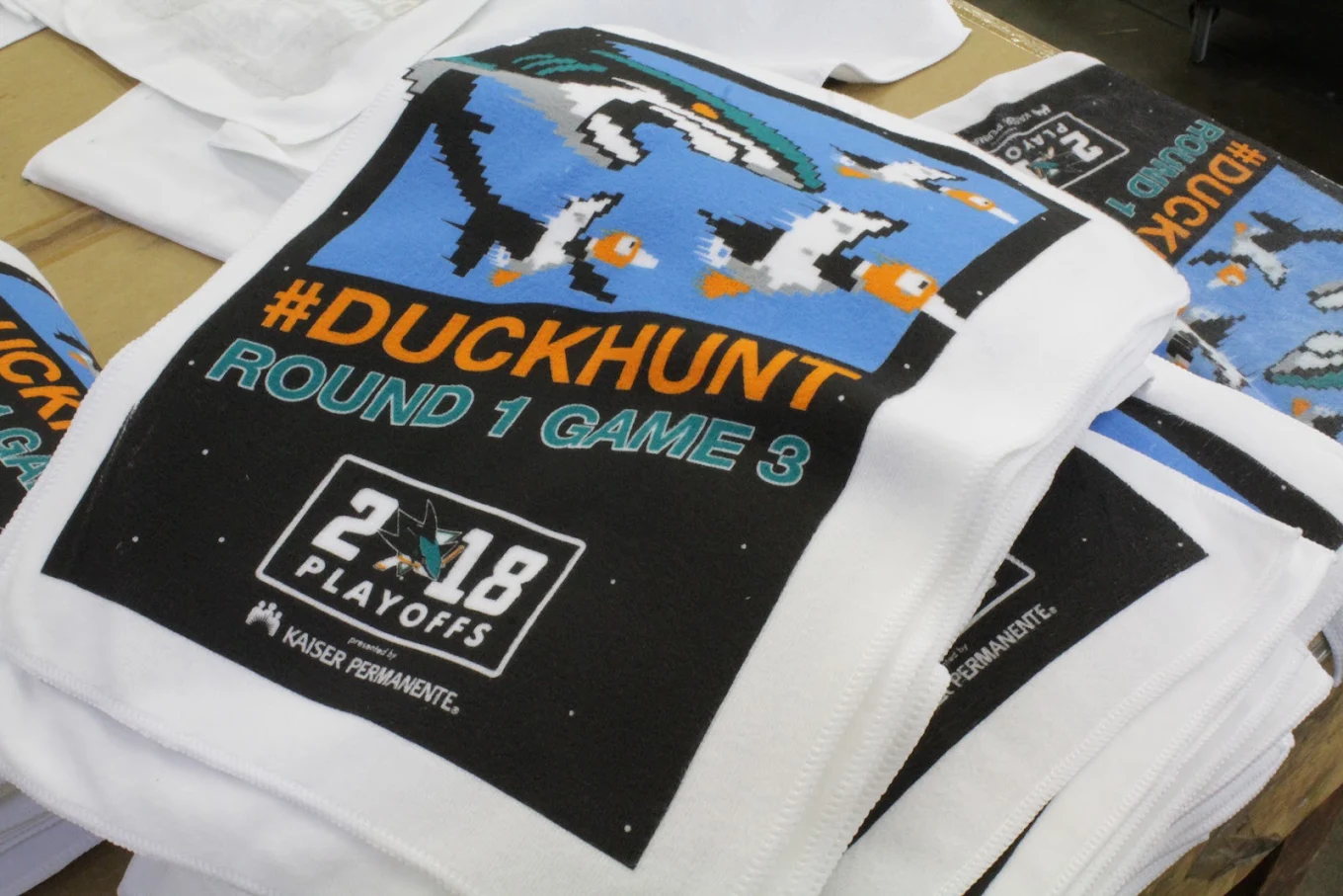 Stacked white tournament shirts with full front graphics