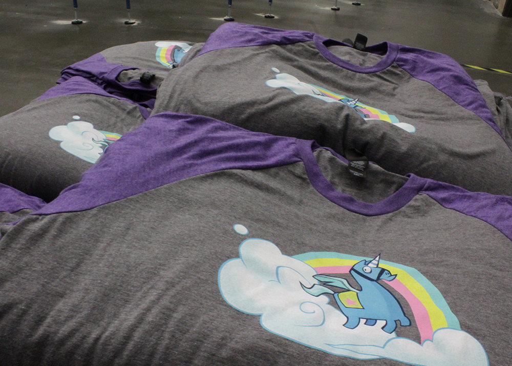 Multiple youth program shirts laid out after printing