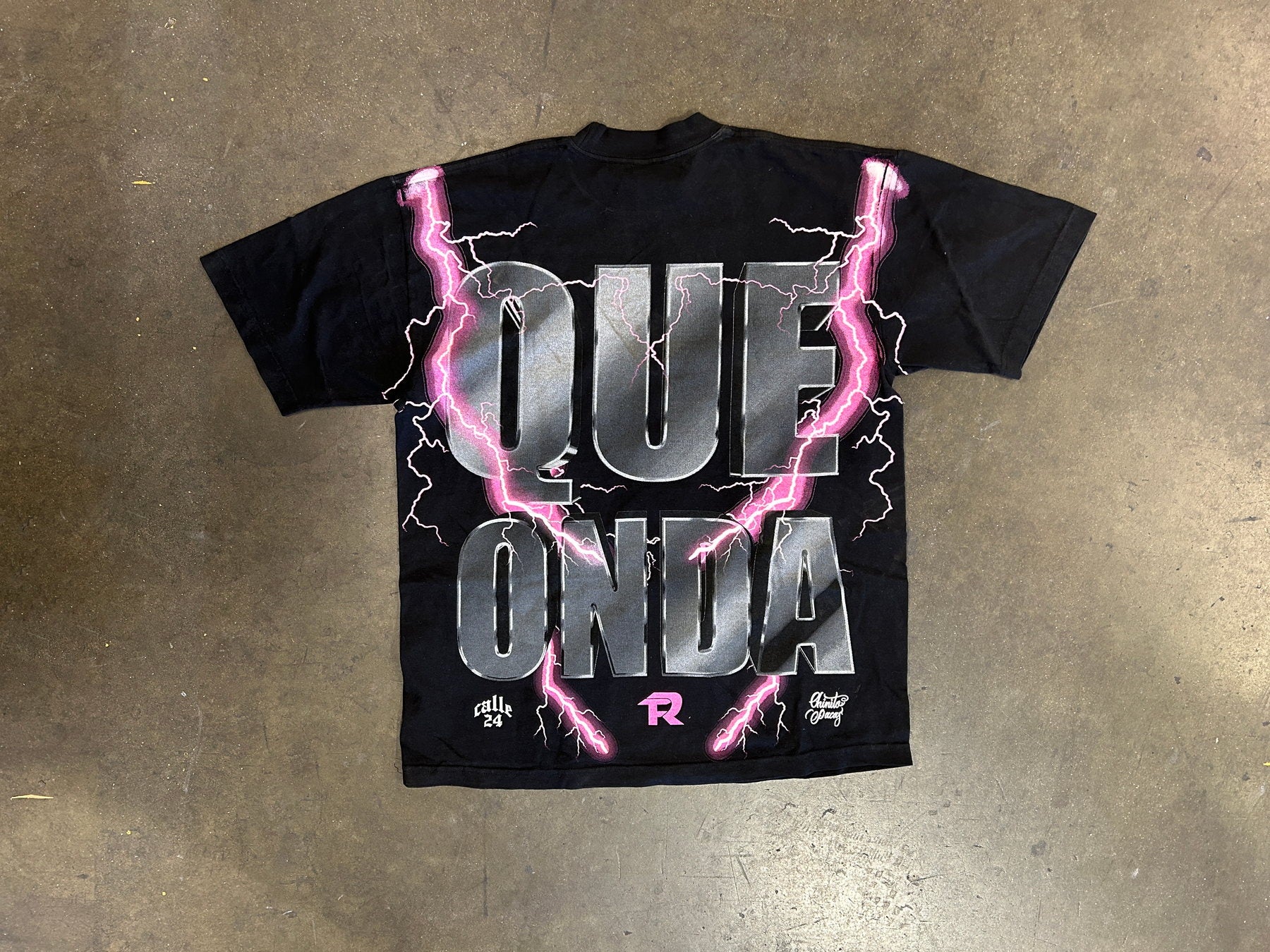 Black t-shirt with oversized Que Onda back graphic and pink lightning artwork